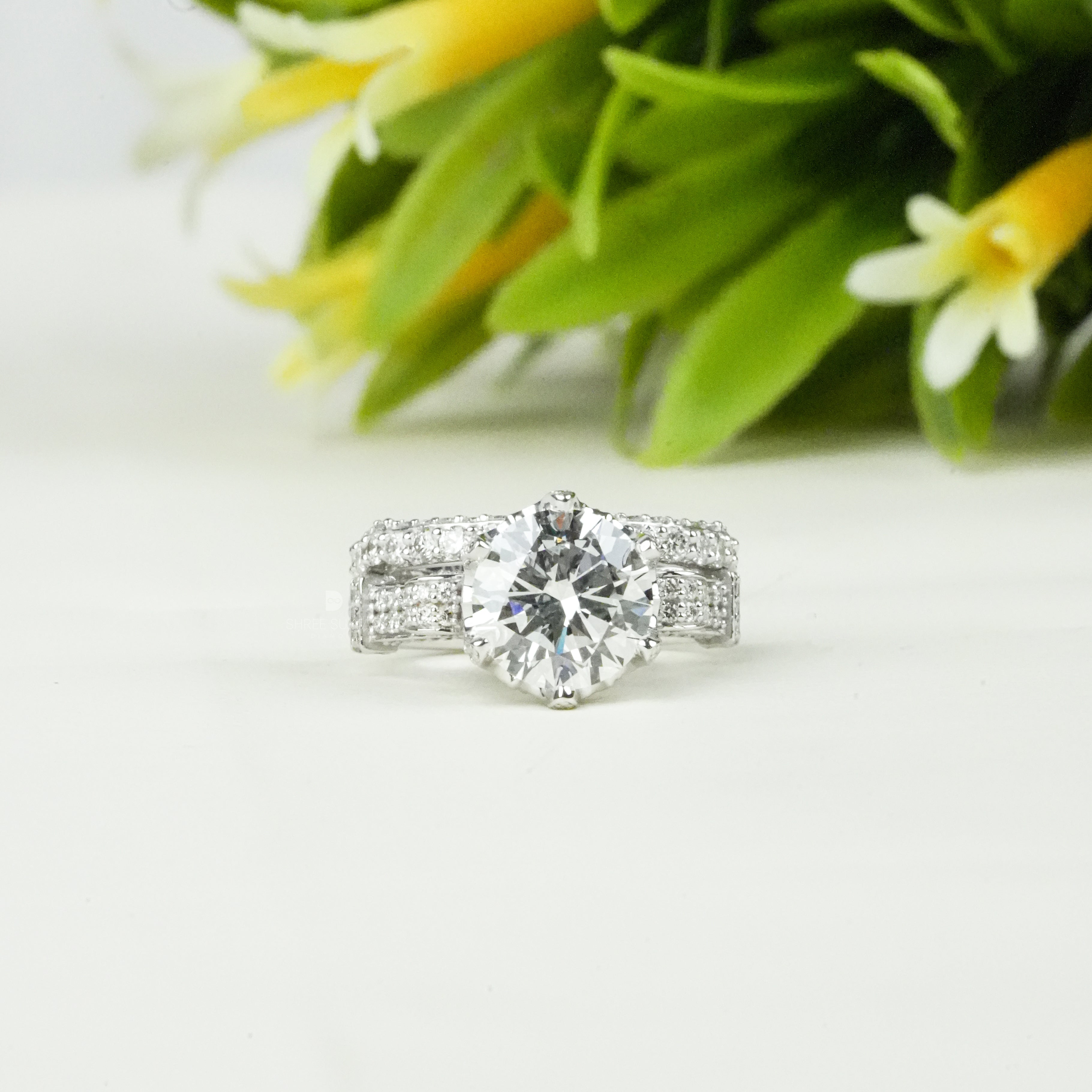 Elegant round-cut diamond engagement ring in white gold with a brilliant solitaire centerpiece and a stunning multi-row pavé diamond band. This sparkling bridal ring set combines timeless sophistication with modern luxury, making it perfect for engagements, weddings, anniversaries, or special occasions. The brilliant-cut stone and dazzling side diamonds enhance brilliance and elegance, ideal for a classic yet glamorous jewelry statement.