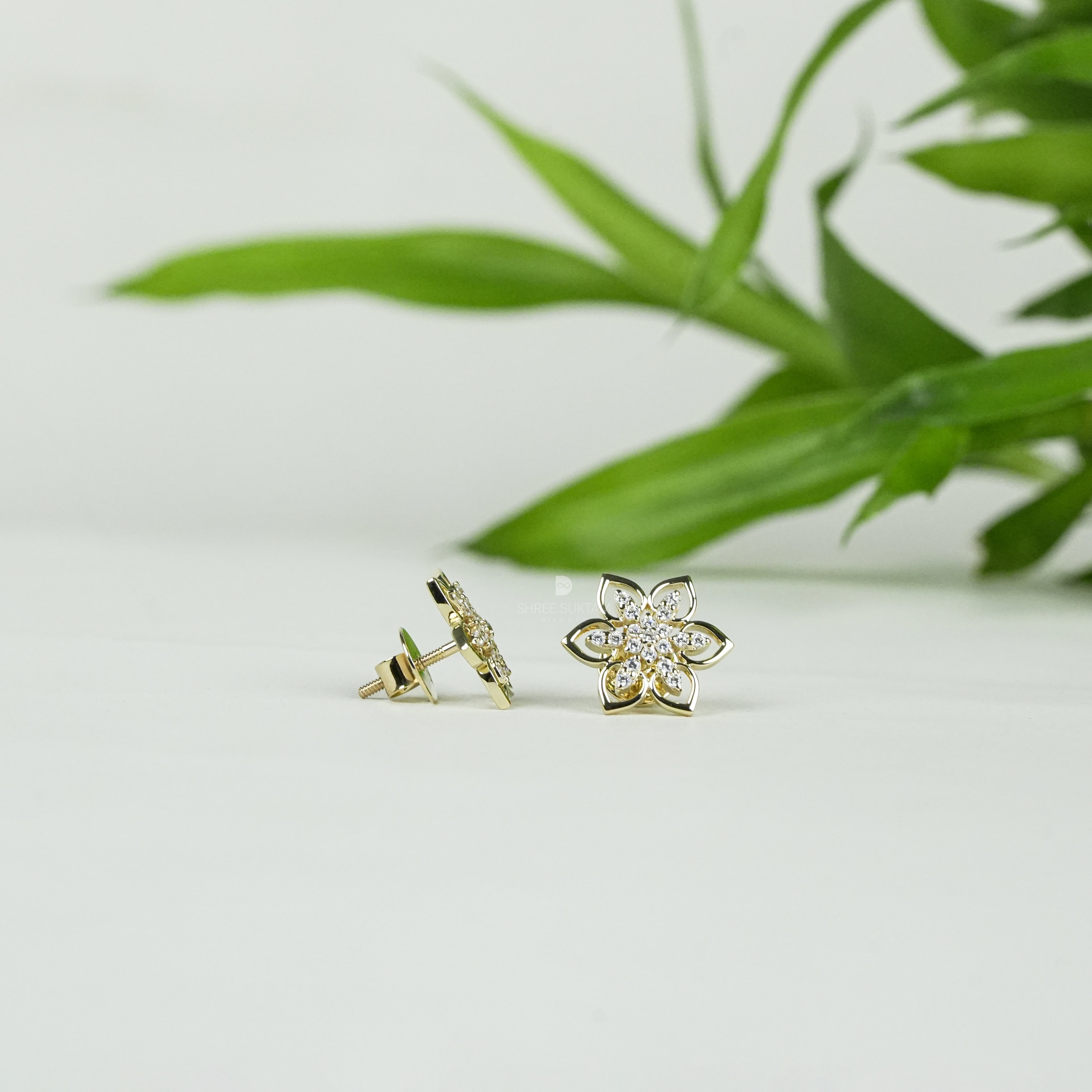 Elegant gold floral stud earrings featuring a delicate six-petal flower design adorned with sparkling cubic zirconia stones, perfect for everyday wear or special occasions. Crafted with fine attention to detail, these gold-plated earrings add a touch of timeless charm and sophistication. Ideal as a gift for women, these versatile studs pair beautifully with both casual and formal outfits, enhancing any jewelry collection.